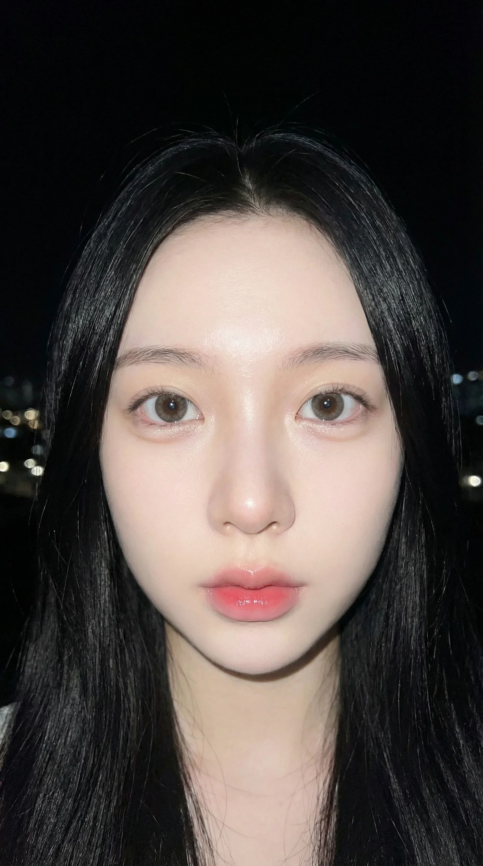 Douyin aesthetic extreme close-up night selfie of young Asian woman with direct flash creating porcelain mochi skin effect, large puppy eyes, gradient heart lips, black bokeh background